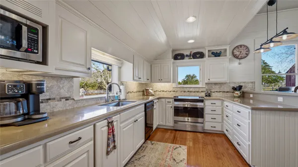 a large kitchen with stainless steel appliances granite countertop a stove and a sink