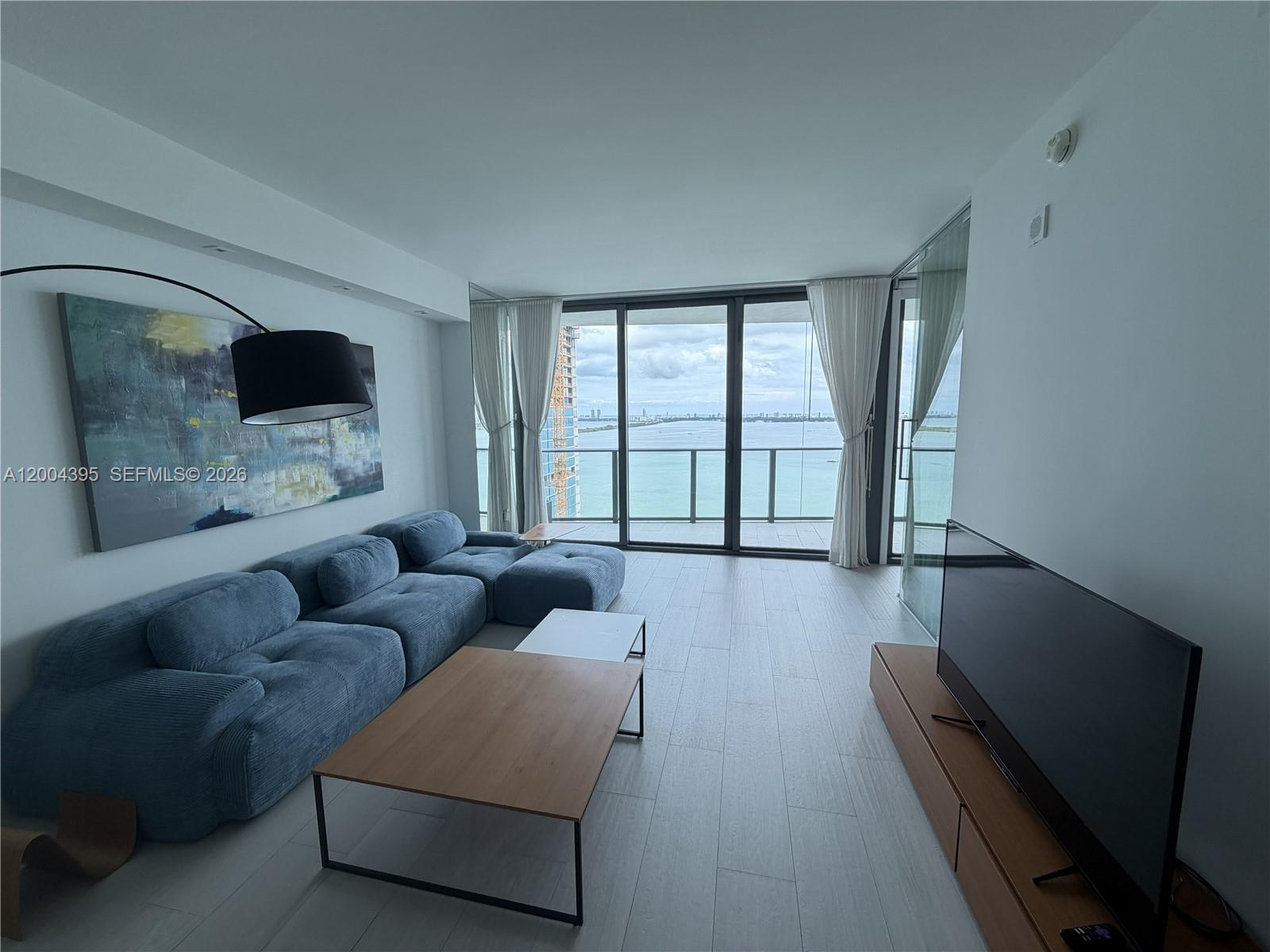 460 Northeast 28th Street, Unit 2806 Miami, FL 33137 - Photo 2 of 10 a living room with furniture and a flat screen tv