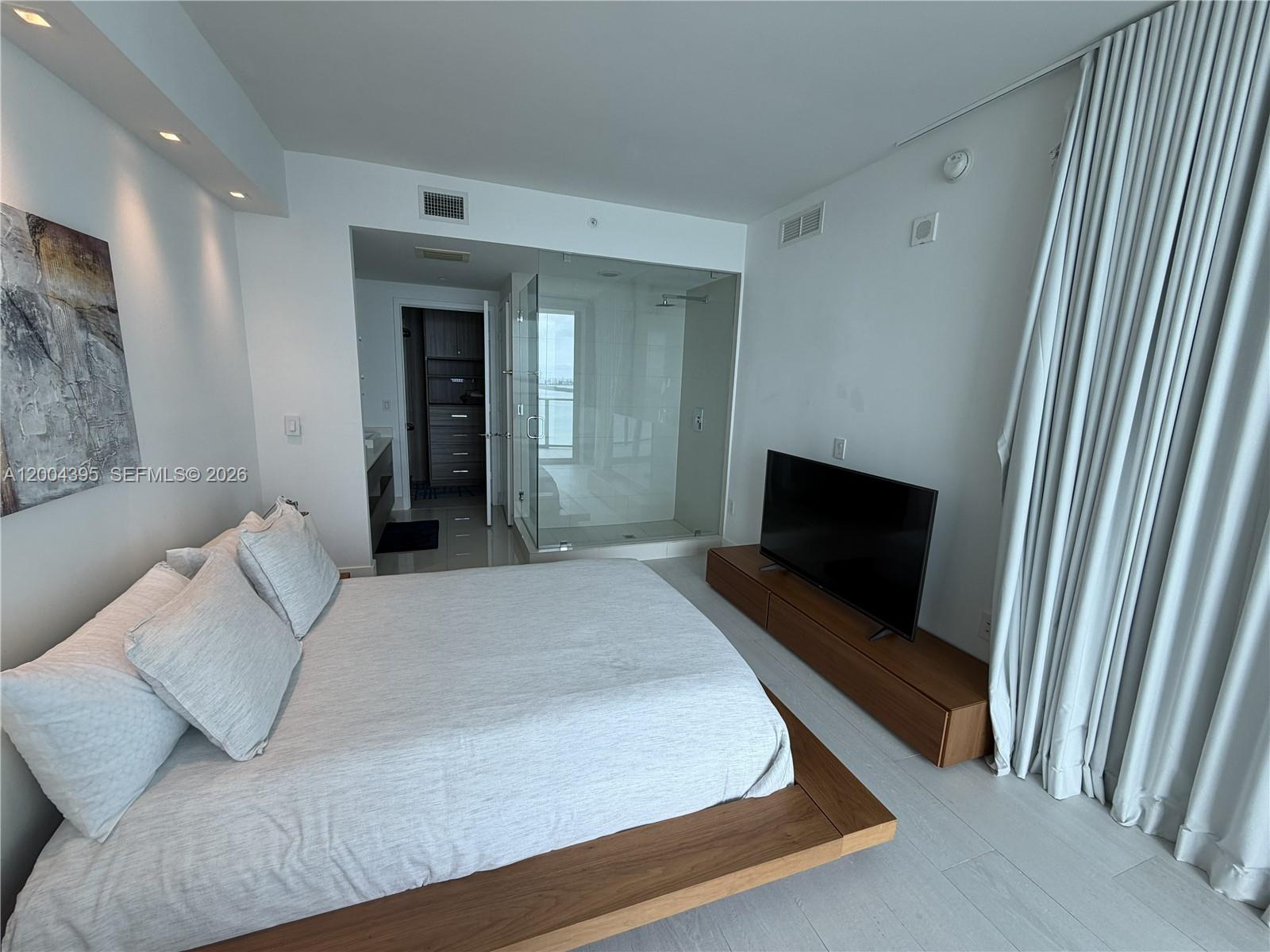 460 Northeast 28th Street, Unit 2806 Miami, FL 33137 - Photo 5 of 10 a bedroom with a bed and a television