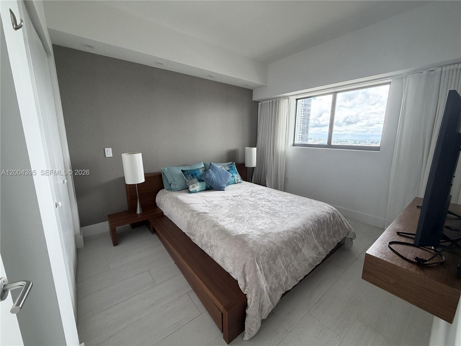 460 Northeast 28th Street, Unit 2806 Miami, FL 33137 - Photo 7 of 10 a bedroom with a bed and a window
