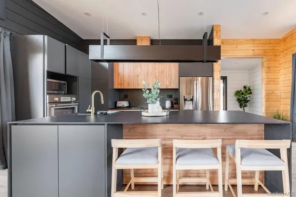 a kitchen with stainless steel appliances granite countertop a sink a stove and a refrigerator