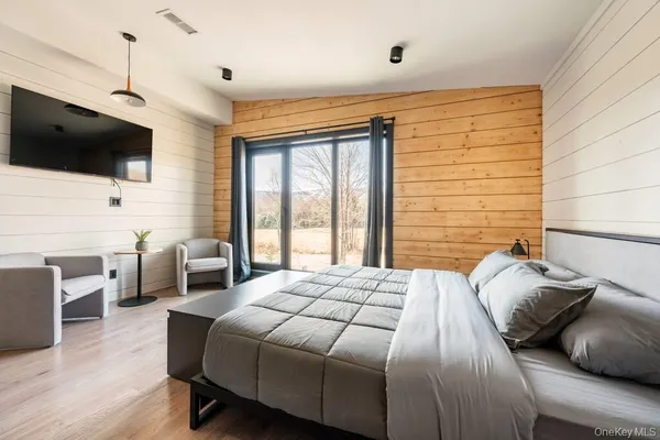 a bedroom with a bed and wooden floor