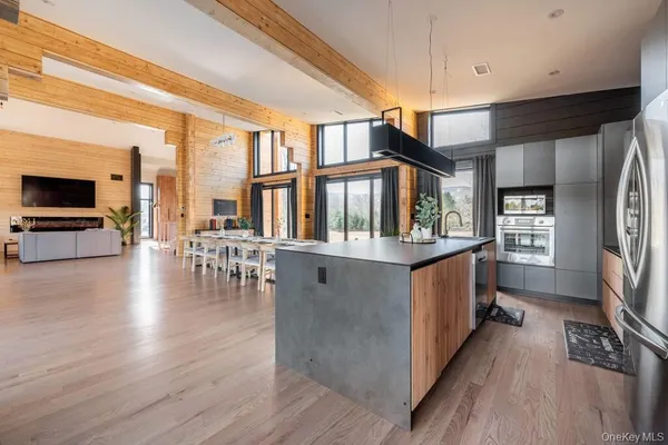 a living room with stainless steel furniture wooden floor and a flat screen tv