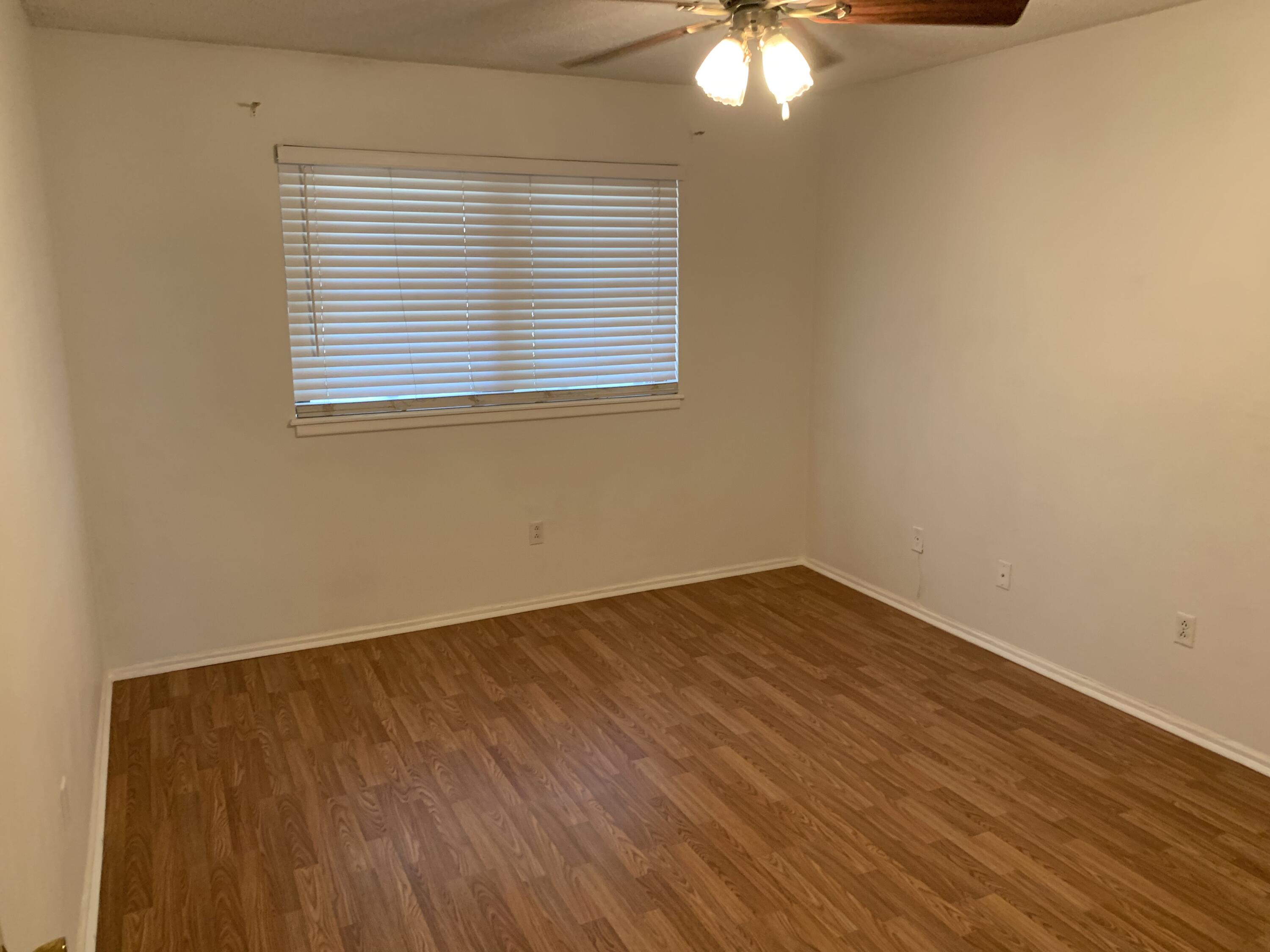5201 15th Street Lubbock, TX 79416 - Photo 12 of 16 a view of an empty room with wooden floor and a window