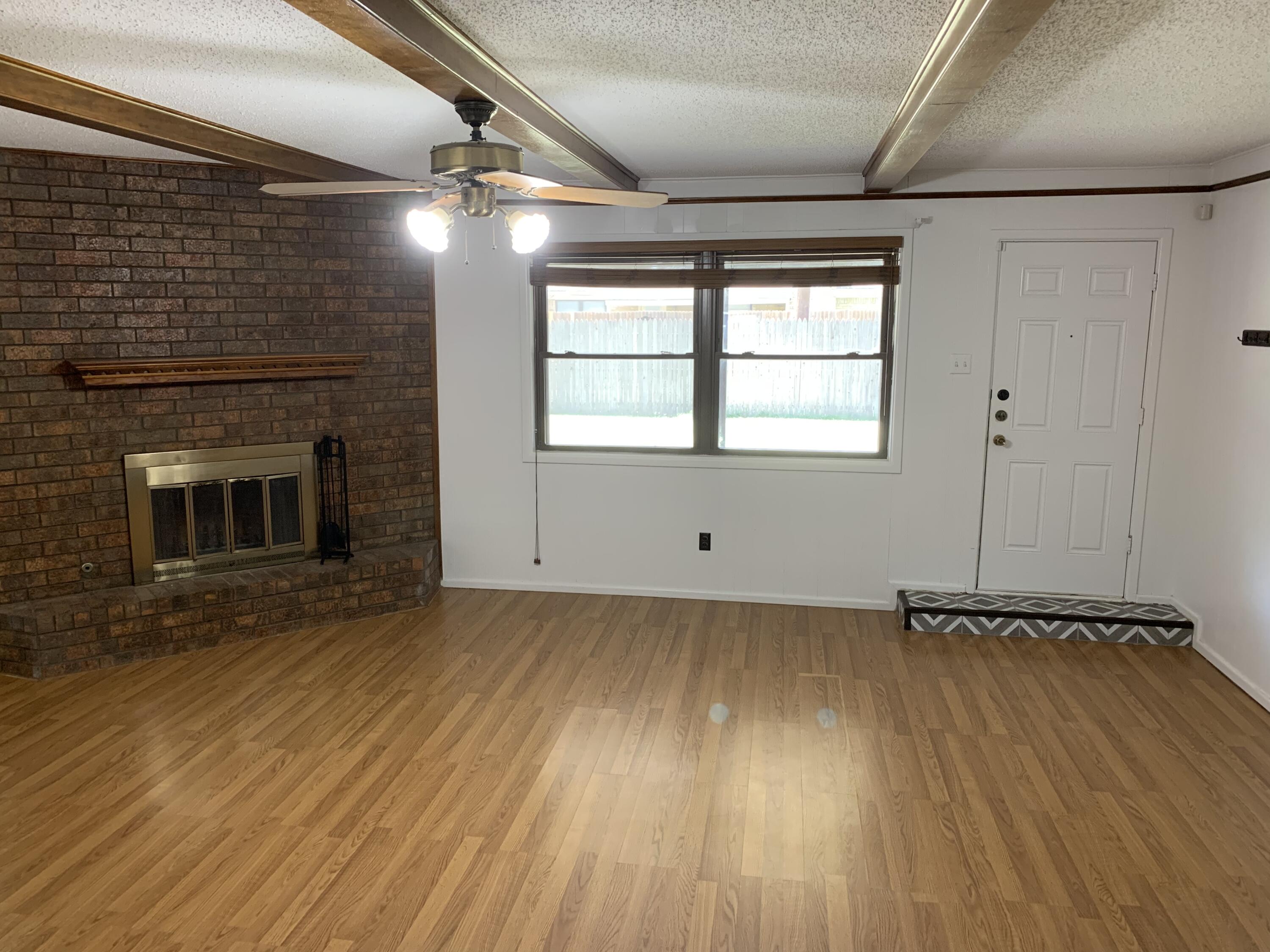 5201 15th Street Lubbock, TX 79416 - Photo 8 of 16 a view of a room with wooden floors and fireplace