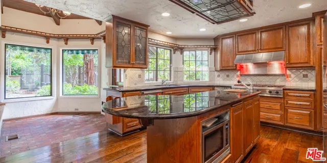 a kitchen with stainless steel appliances granite countertop a refrigerator and a stove