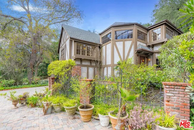 a front view of a house with a yard and fountain