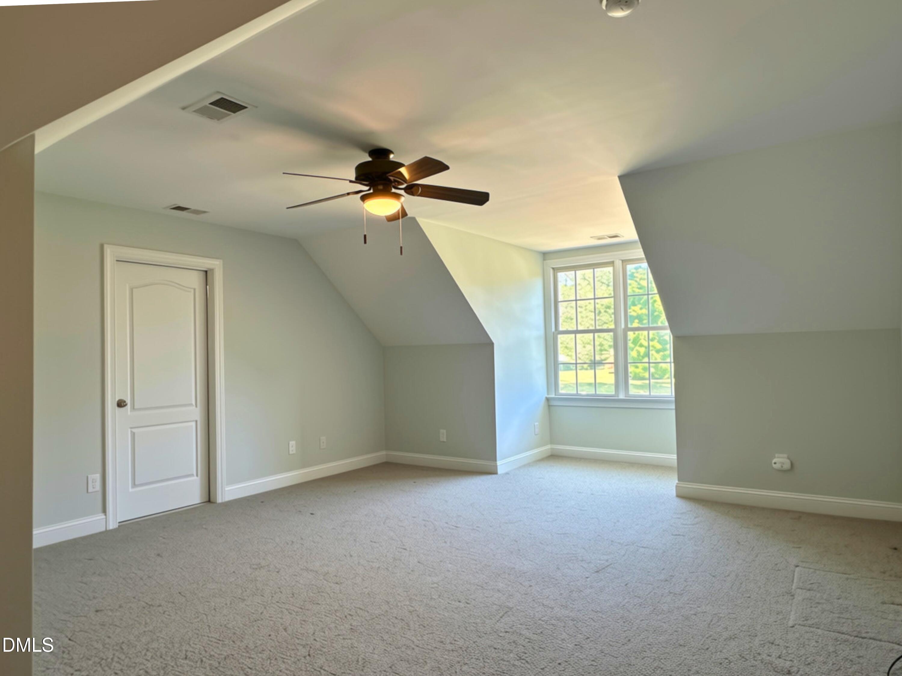 3100 Donlin Drive Wake Forest, NC 27587 - Photo 47 of 67 Carpeted room with sloped ceilings and a ceiling fan, featuring a multi-paned window and a paneled door