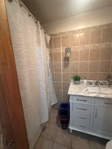 a bathroom with a granite countertop sink a toilet and shower