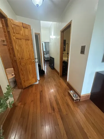 a view of a hallway with wooden floor and stairs