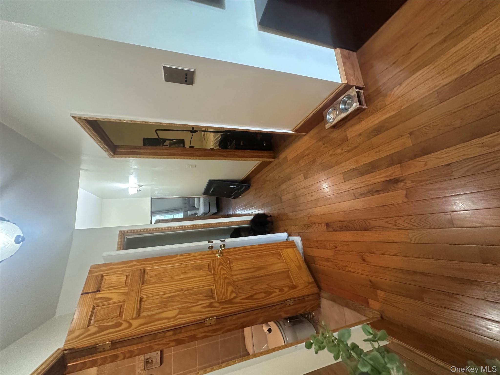 1245 Madison Street Brooklyn, NY 11221 - Photo 2 of 15 a view of a hallway with wooden floor and stairs