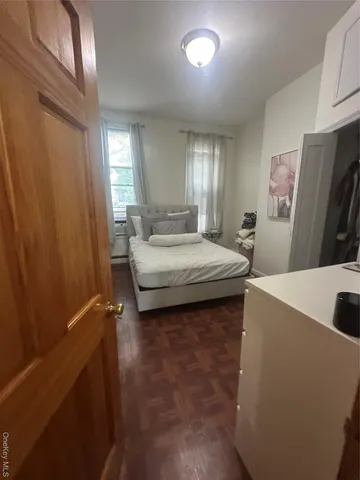 a living room with stainless steel appliances wooden floor and large window