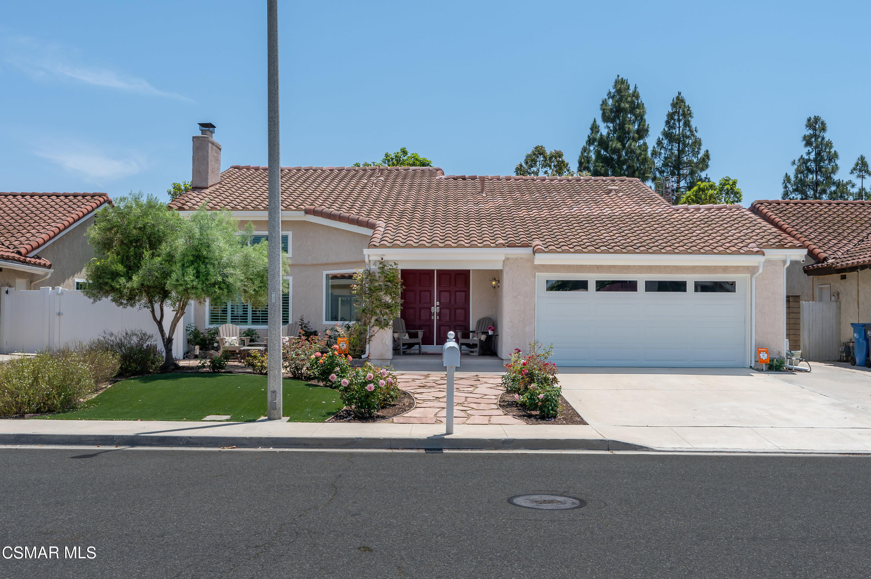 a front view of a house with a yard and potted plants