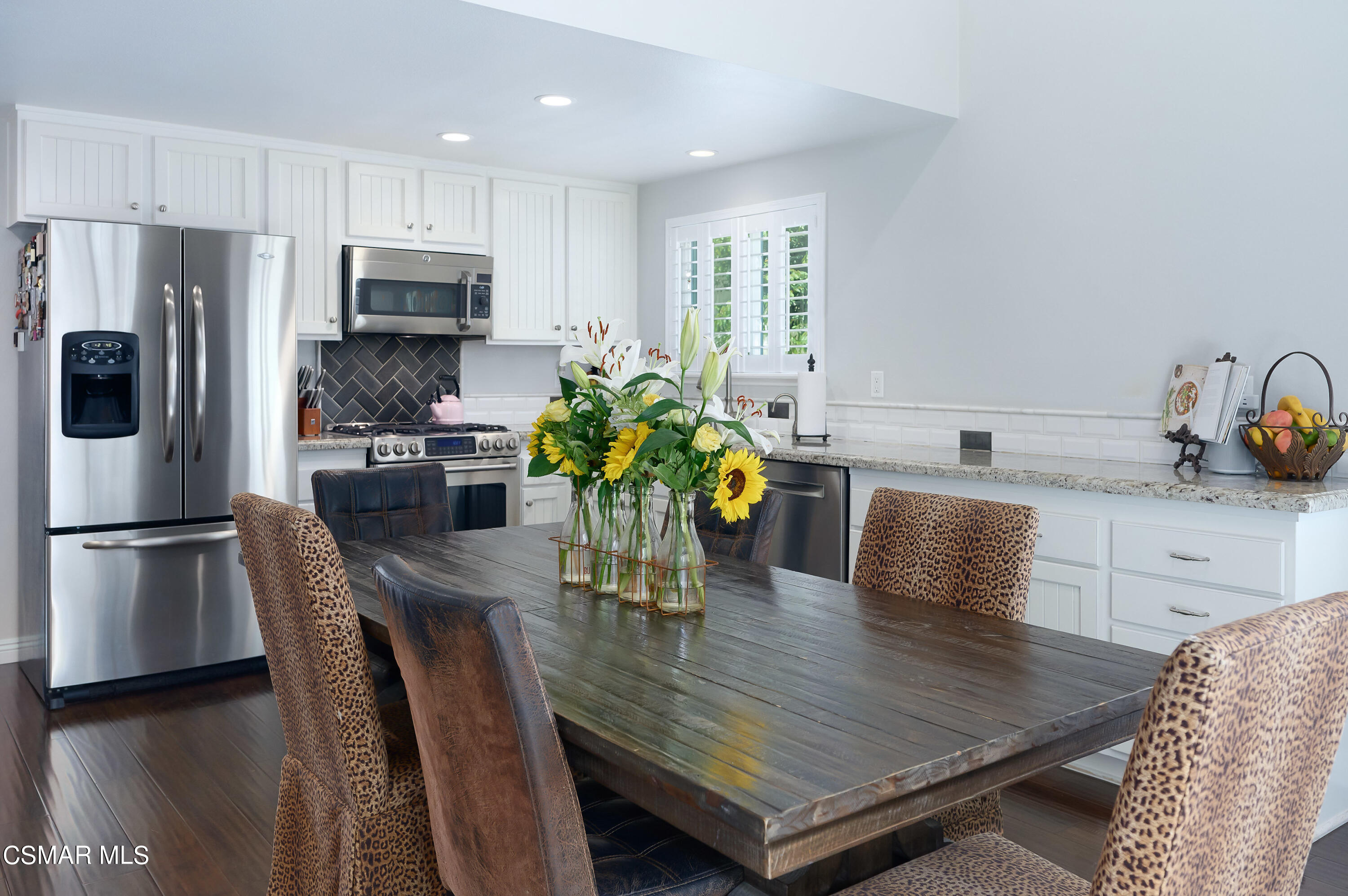 4798 Talmadge Road Moorpark, CA 93021 - Photo 17 of 65 a kitchen with stainless steel appliances a dining table chairs refrigerator and microwave
