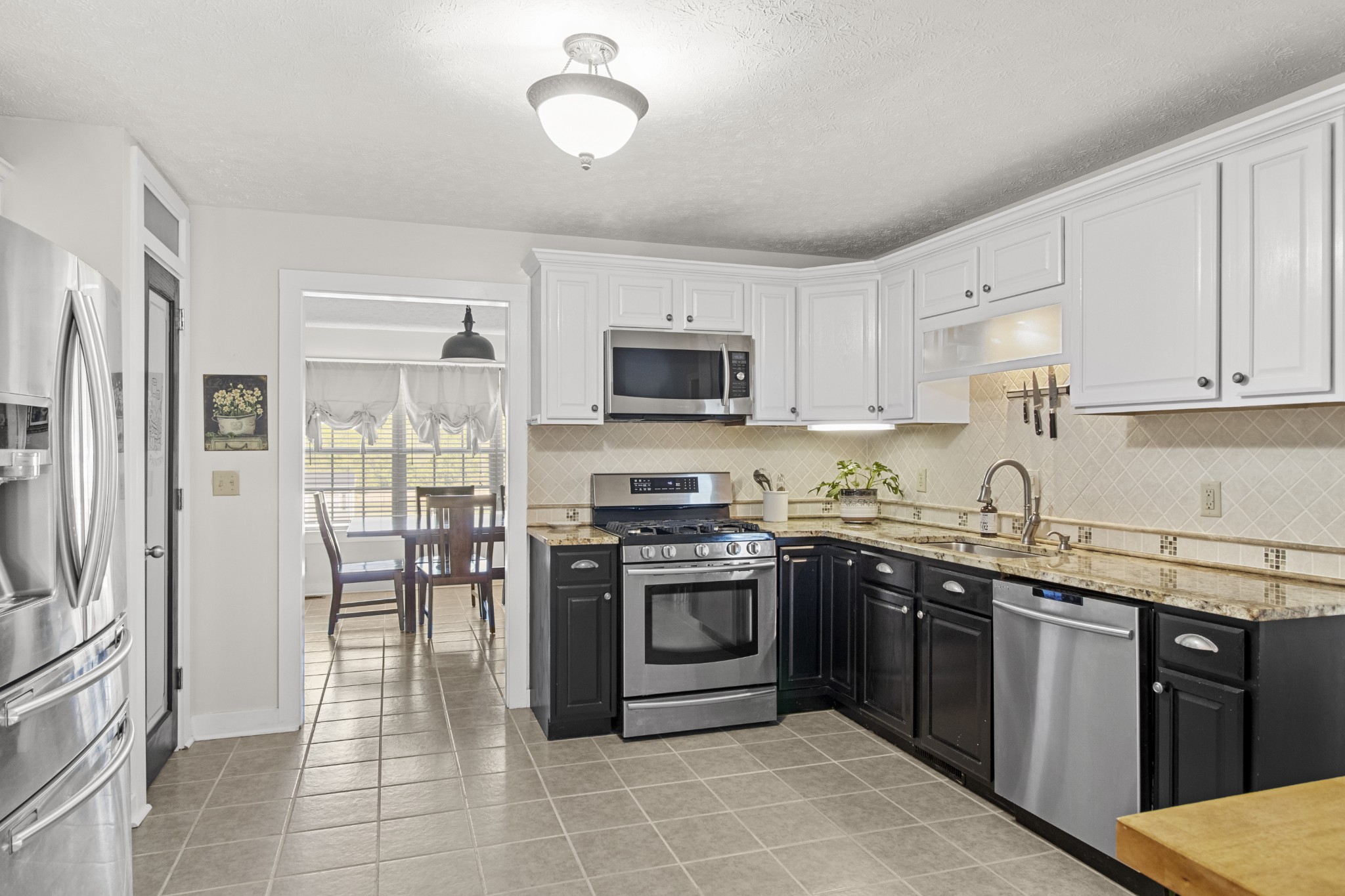 884 Tidwell Road Burns, TN 37029 - Photo 12 of 28 a kitchen with stainless steel appliances granite countertop a stove top oven a sink dishwasher a refrigerator and a microwave