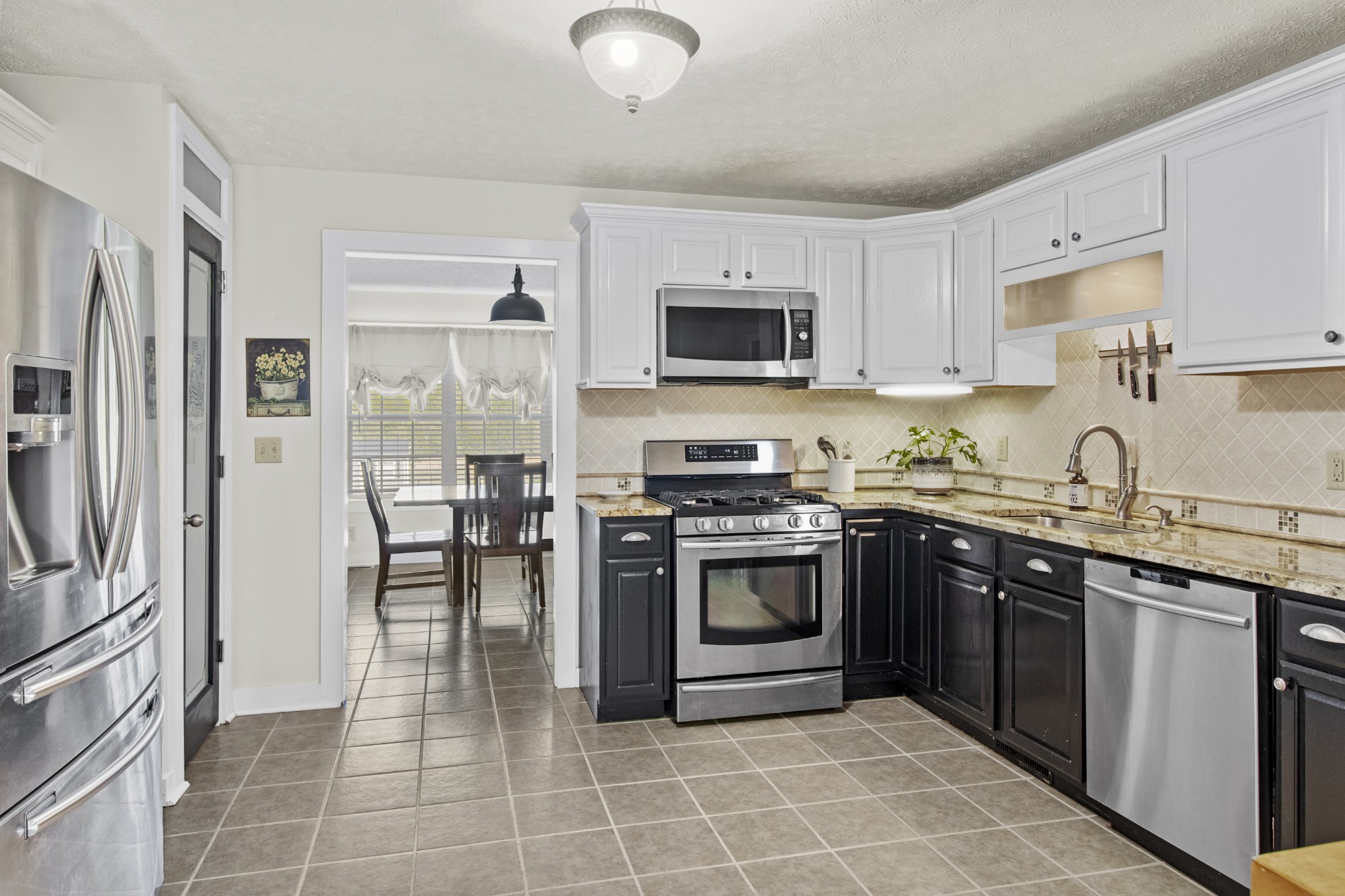 884 Tidwell Road Burns, TN 37029 - Photo 16 of 28 a kitchen with stainless steel appliances granite countertop a stove top oven a sink dishwasher a refrigerator and a microwave