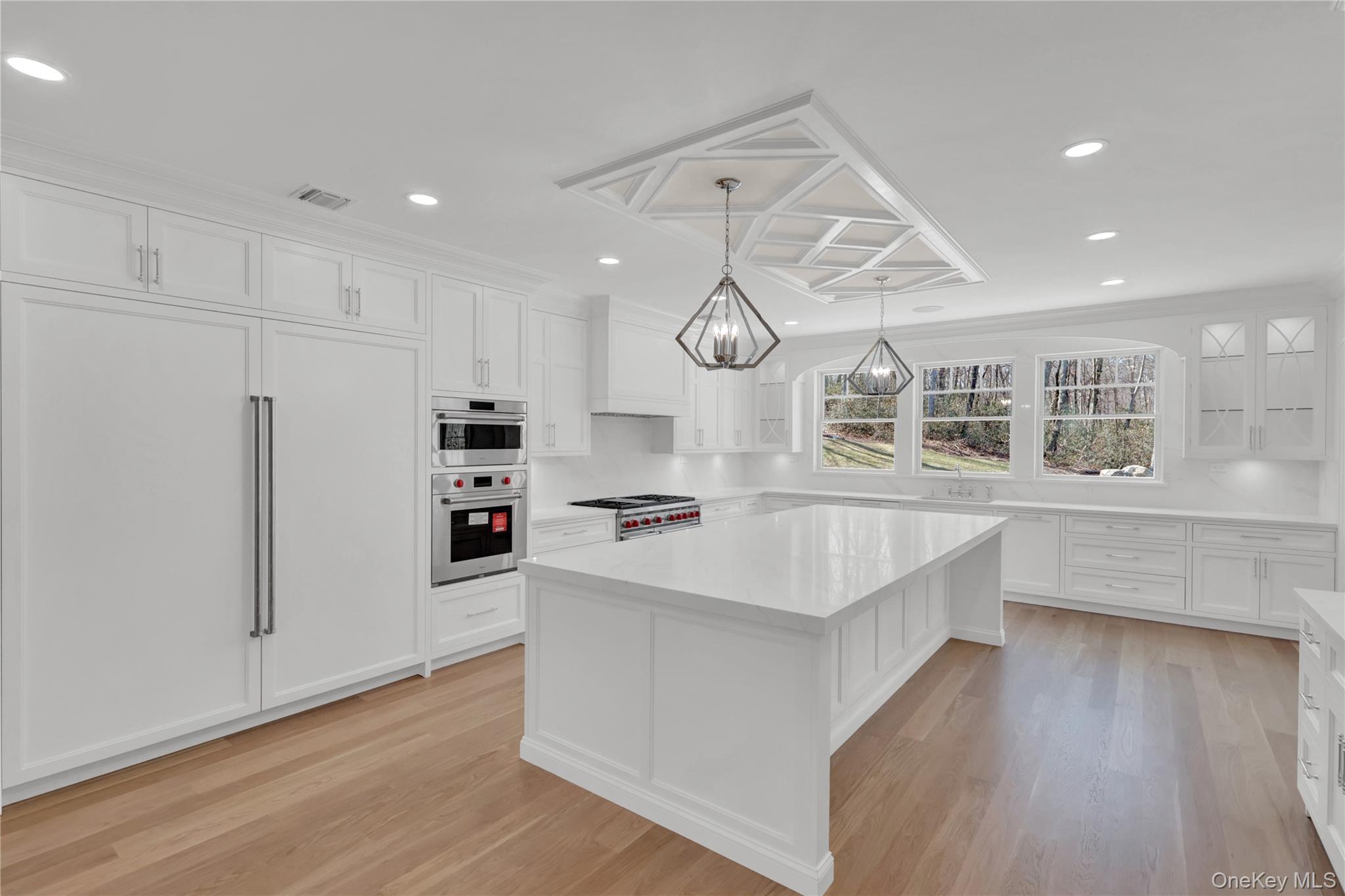 541 Split Rock Road Syosset, NY 11791 - Photo 21 of 50 a large kitchen with stainless steel appliances a large counter top and a wooden floors