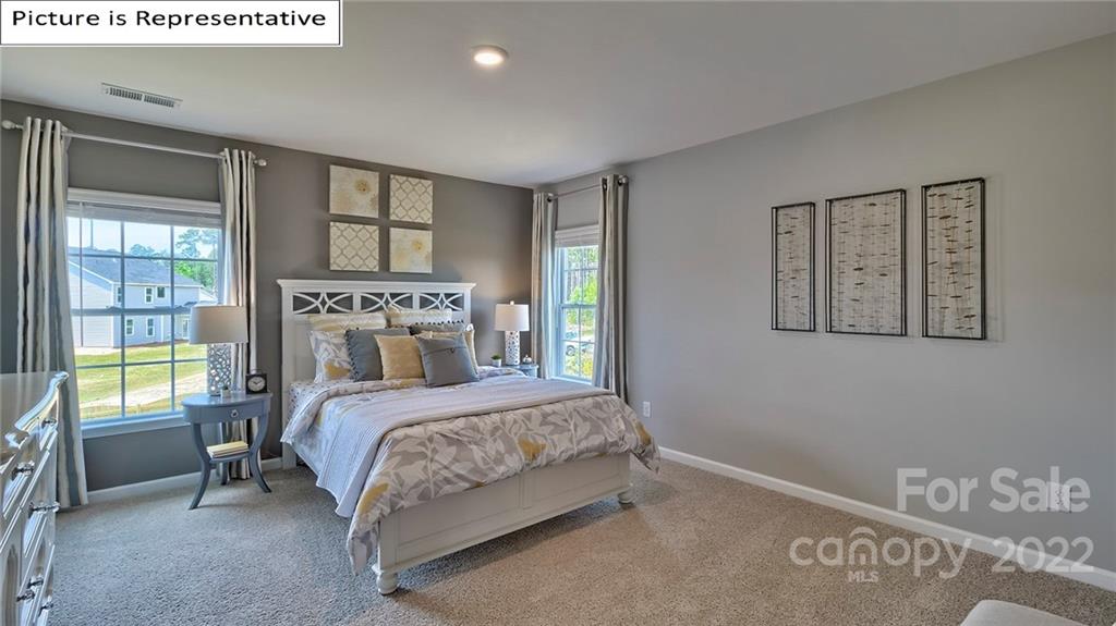 115 Sycamore Xing Court, Unit 75 Locust, NC 28097 - Photo 21 of 29 a bedroom with a bed a table and windows