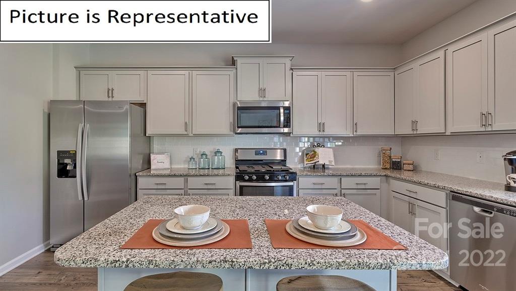 115 Sycamore Xing Court, Unit 75 Locust, NC 28097 - Photo 9 of 29 a kitchen with granite countertop a sink and a stove