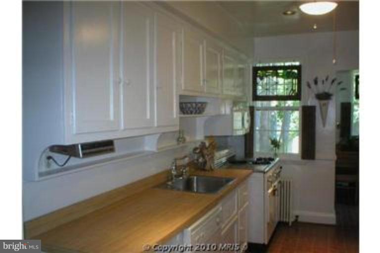 6312 Blackburn Court Baltimore, MD 21212 - Photo 5 of 13 a kitchen with stainless steel appliances granite countertop a sink a stove cabinets and a dining table