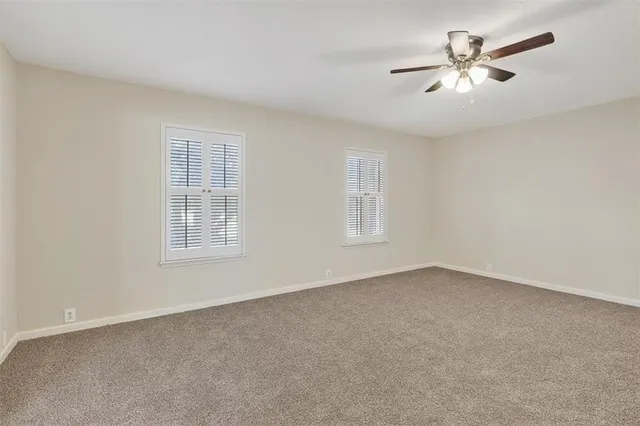 a view of an empty room with a ceiling fan