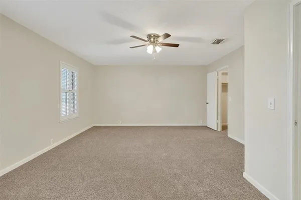 a view of an empty room with a ceiling fan
