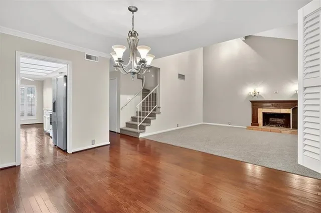 a view of a livingroom with wooden floor and a chandelier