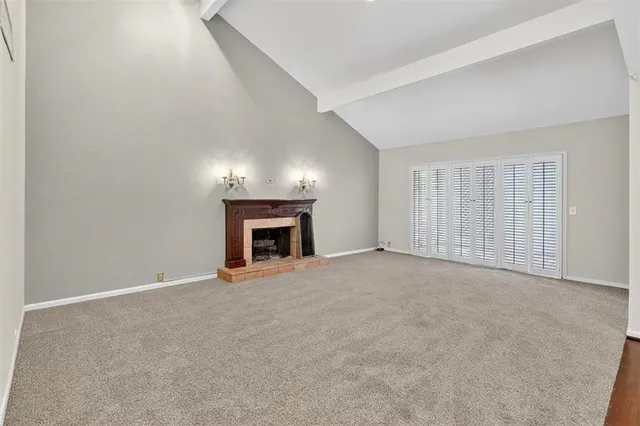 a view of an empty room with a fireplace and a window