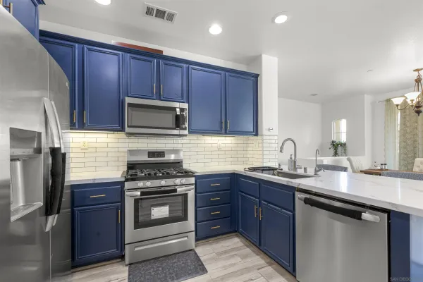 a kitchen with granite countertop wooden cabinets and stainless steel appliances