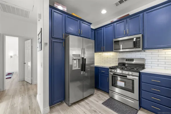 a kitchen with wooden cabinets stainless steel appliances and a wooden floor
