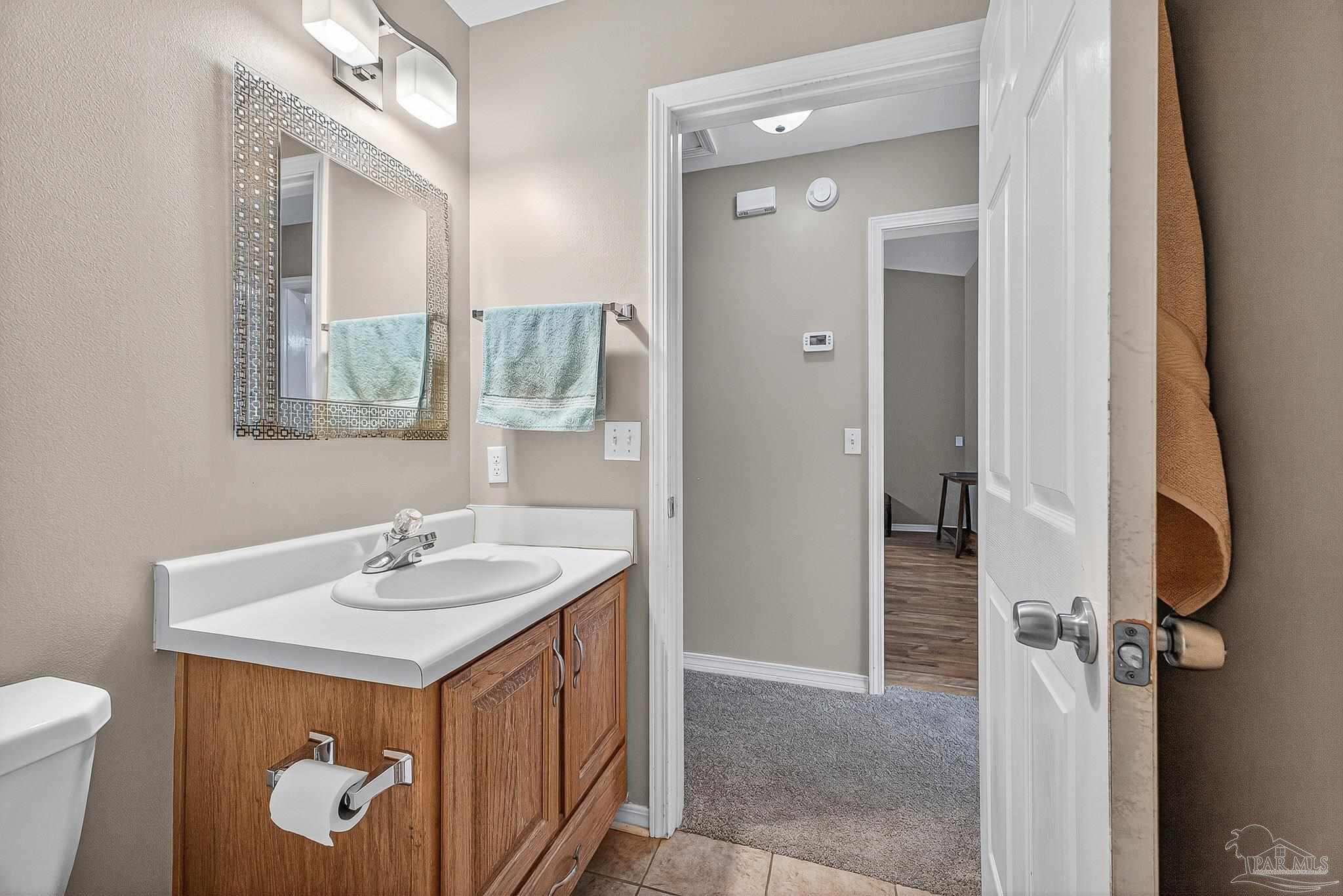 5053 Copperfield Drive Pace, FL 32571 - Photo 16 of 52 a bathroom with a sink a toilet and mirror