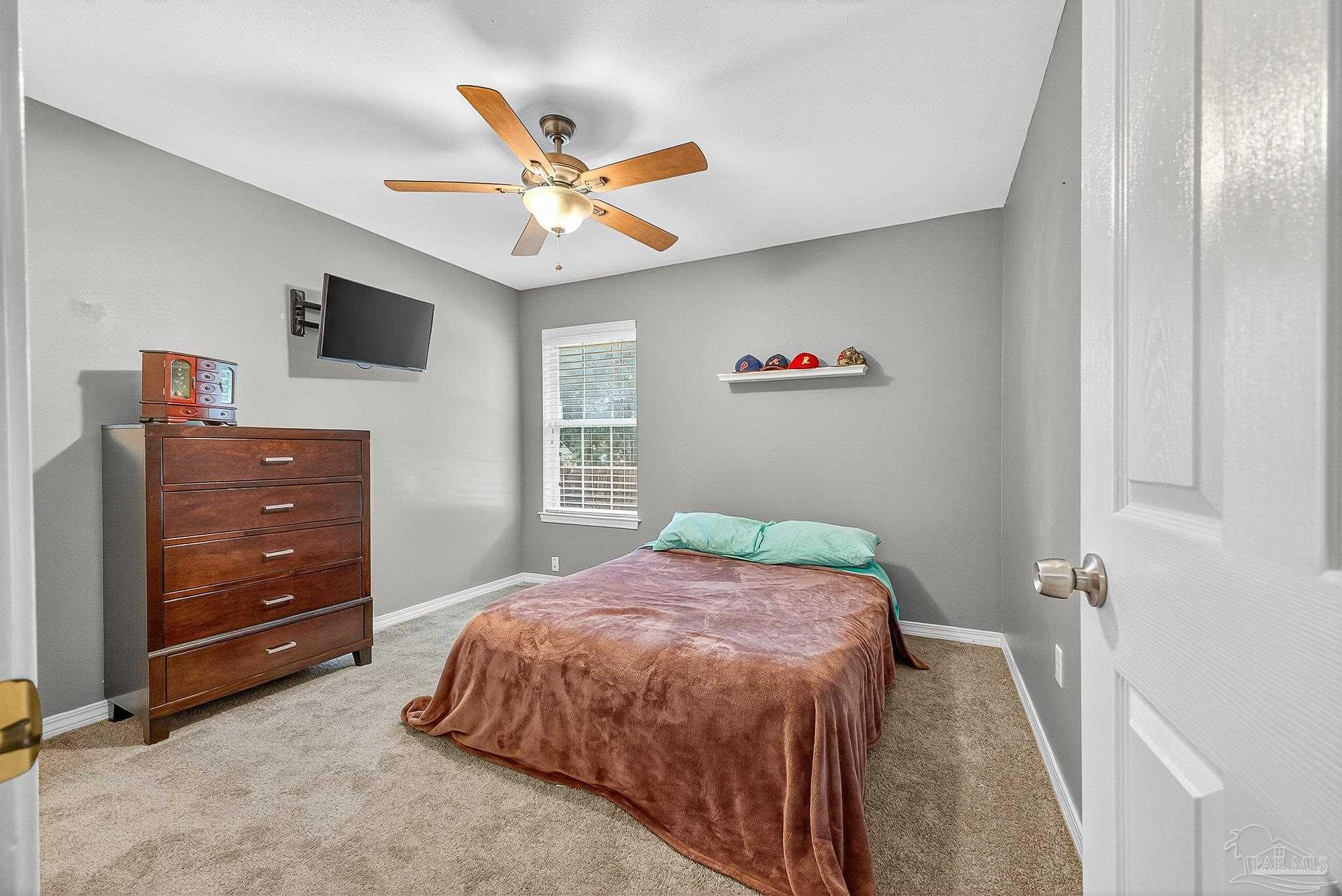 5053 Copperfield Drive Pace, FL 32571 - Photo 17 of 52 a bedroom with a bed and a chandelier