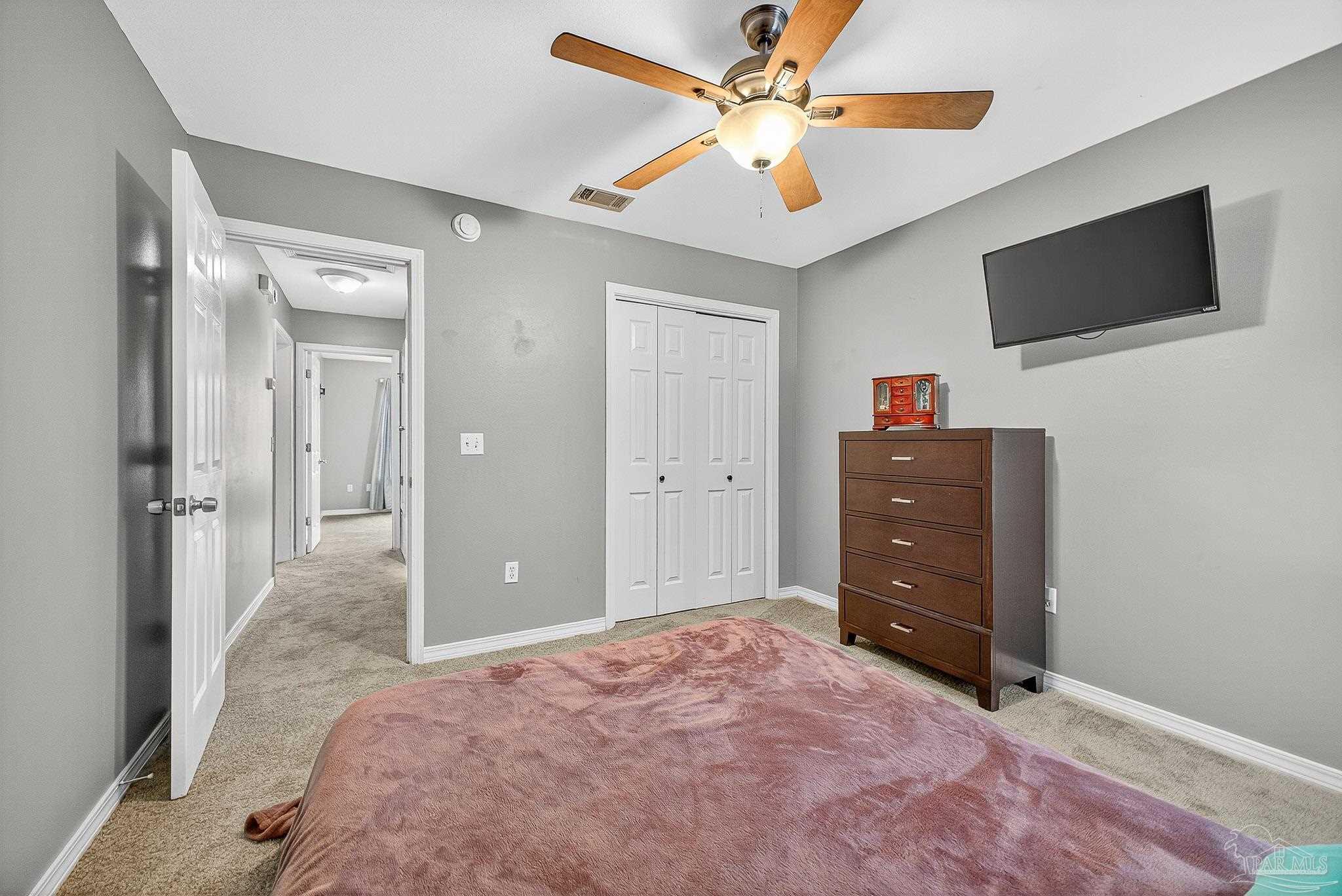 5053 Copperfield Drive Pace, FL 32571 - Photo 18 of 52 a bedroom with a bed and a flat screen tv