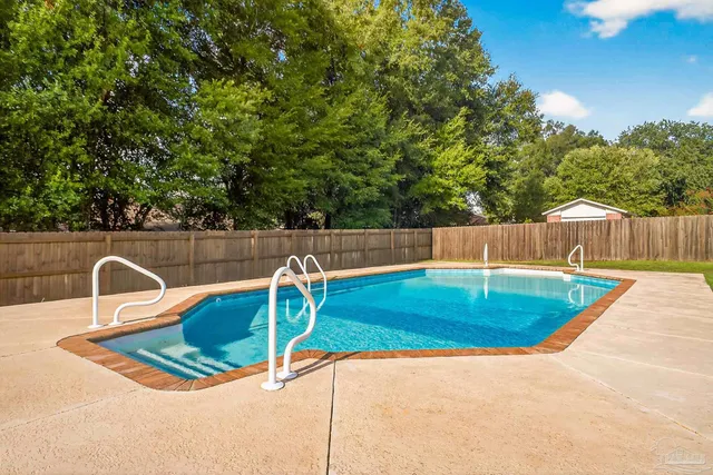 a view of a backyard with swimming pool