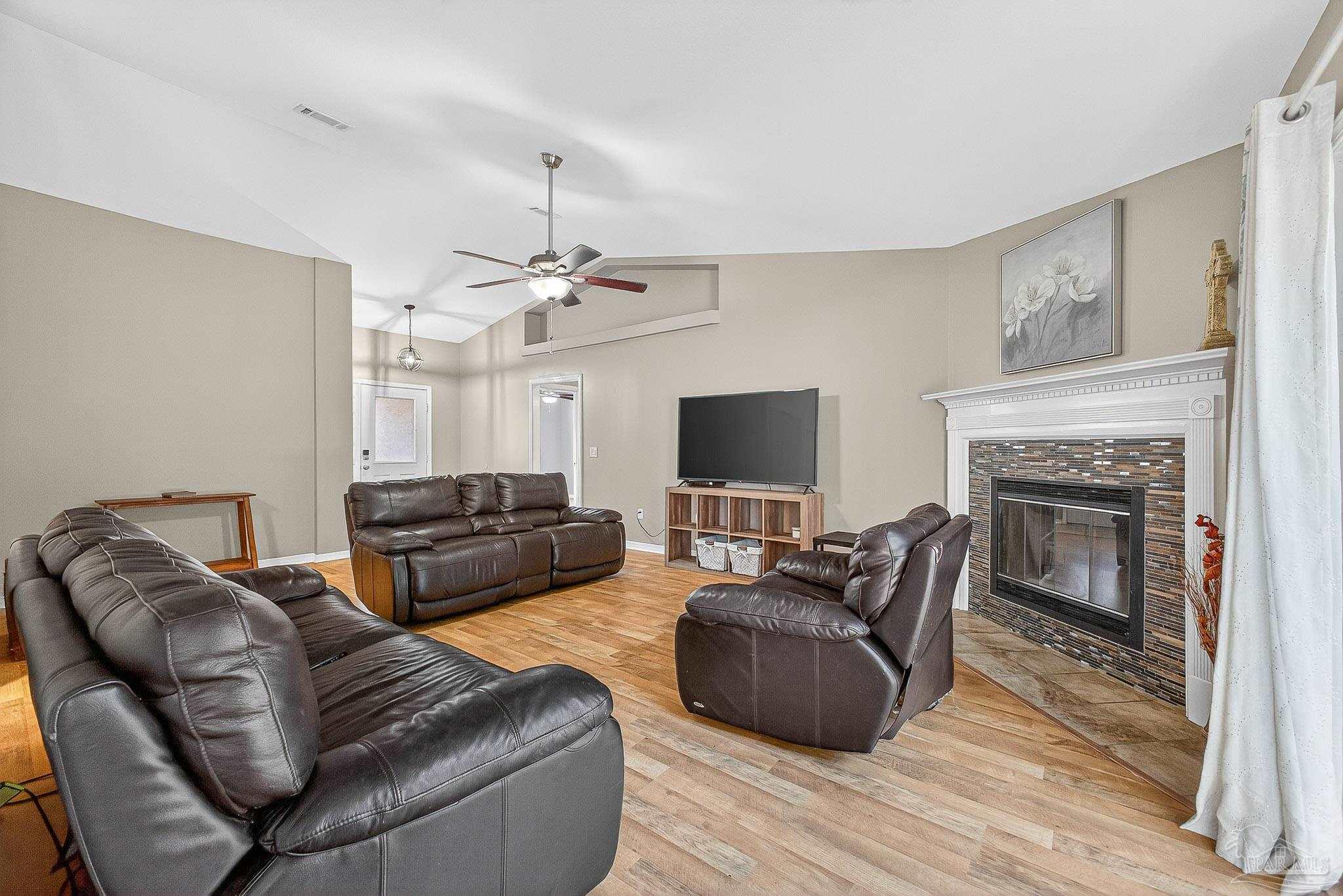 5053 Copperfield Drive Pace, FL 32571 - Photo 23 of 52 a living room with furniture a flat screen tv and a fireplace