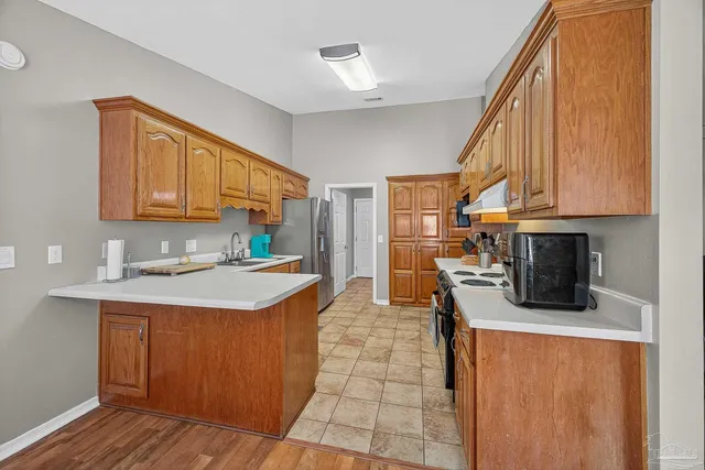 a kitchen with a sink cabinets and wooden floor