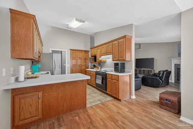 a kitchen with stainless steel appliances granite countertop a refrigerator a sink dishwasher stove with white countertops and cabinets