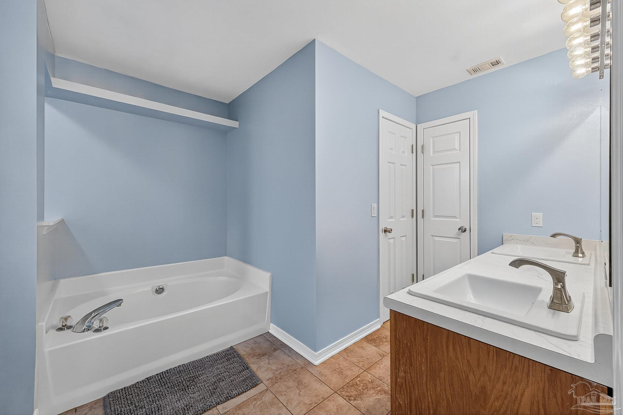 5053 Copperfield Drive Pace, FL 32571 - Photo 35 of 52 a bathroom with a tub sink and mirror