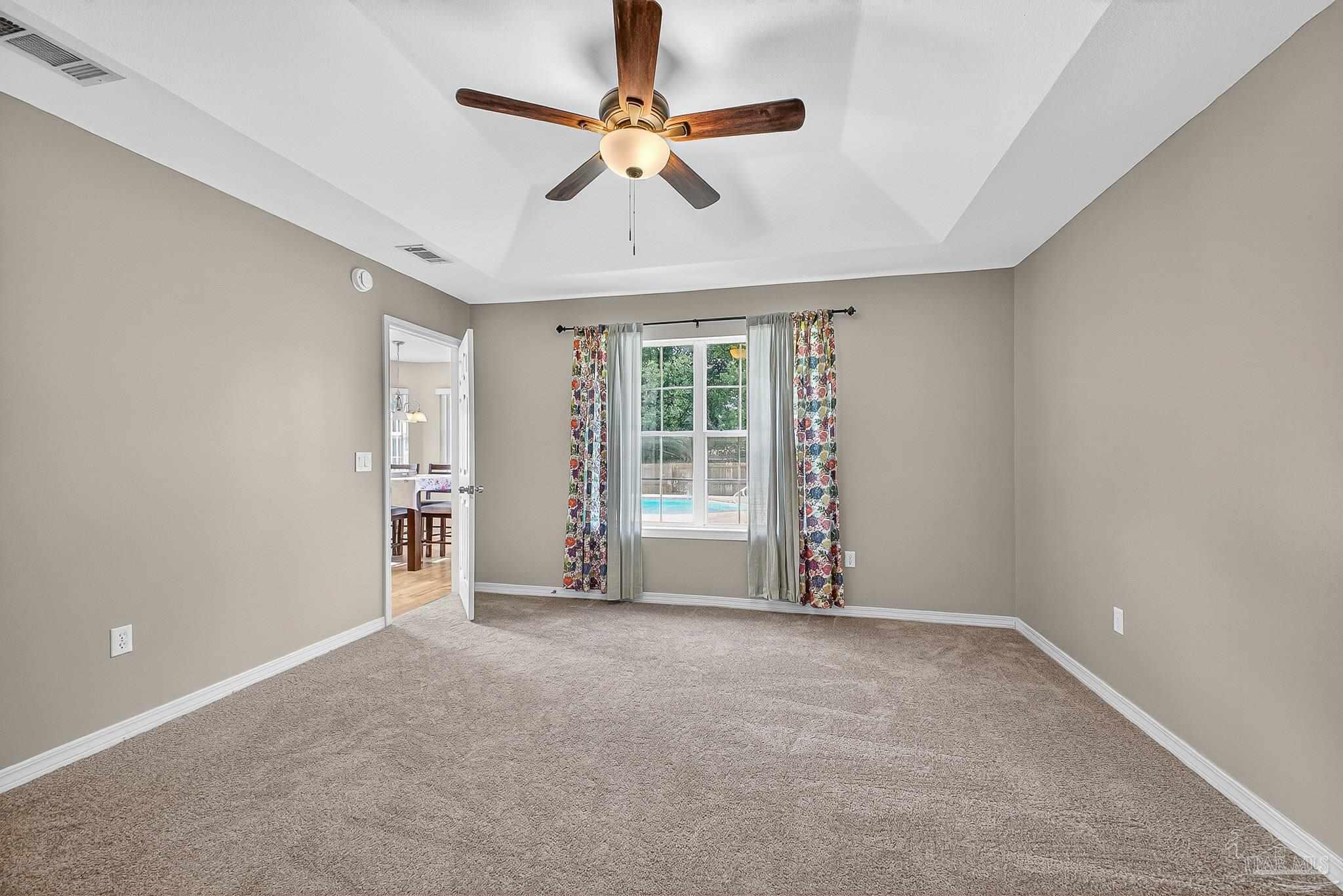 5053 Copperfield Drive Pace, FL 32571 - Photo 38 of 52 an empty room with chandelier fan and windows