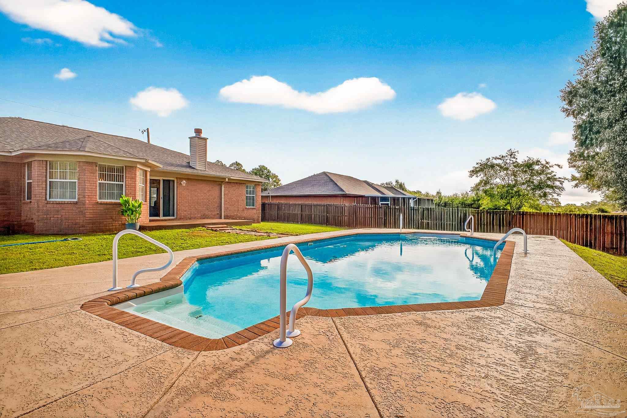 5053 Copperfield Drive Pace, FL 32571 - Photo 47 of 52 a view of a swimming pool with a lounge chairs