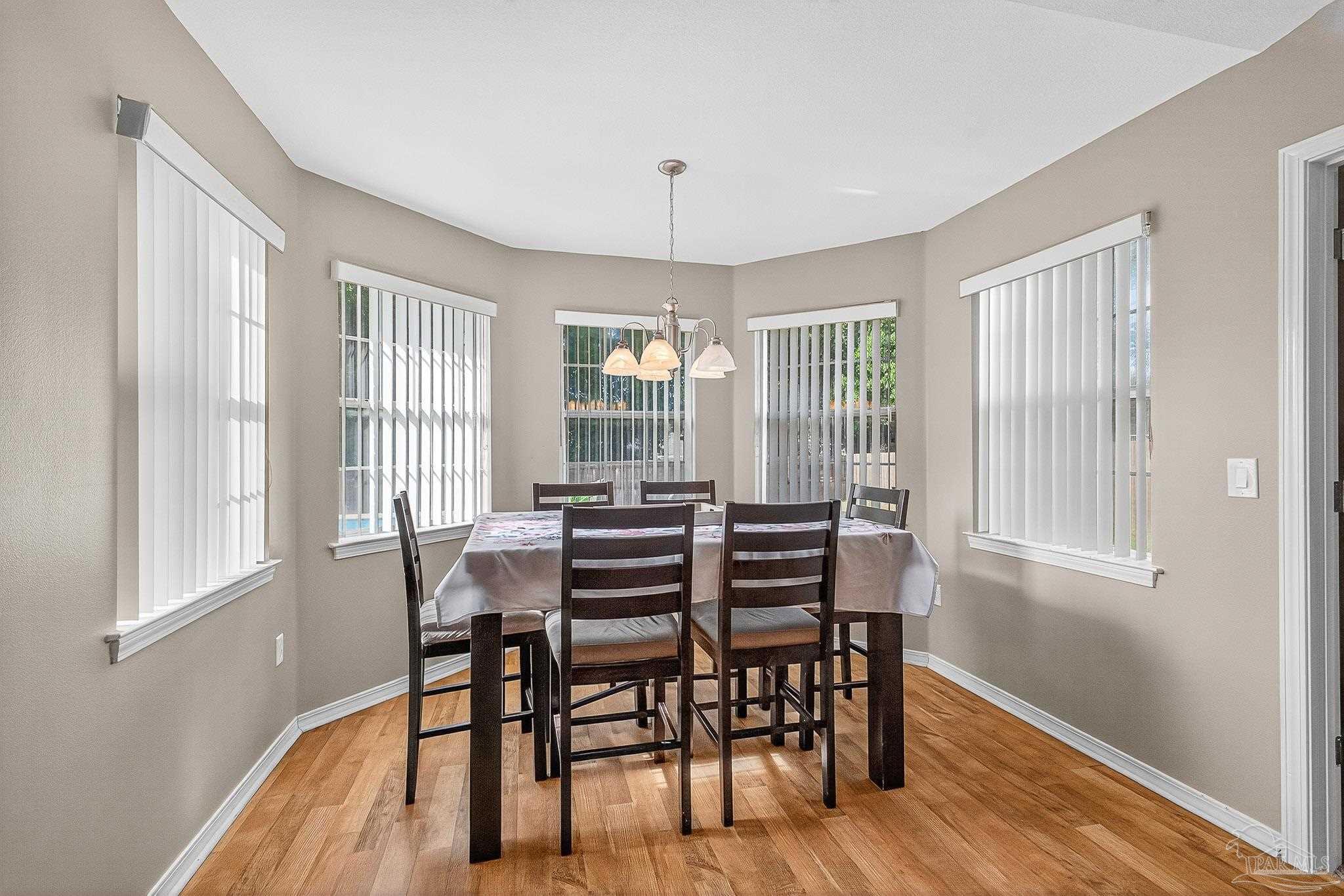 5053 Copperfield Drive Pace, FL 32571 - Photo 5 of 52 a view of a dining room with furniture windows and wooden floor
