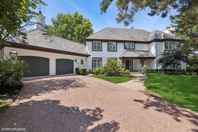 a view of a white house with a yard and potted plants