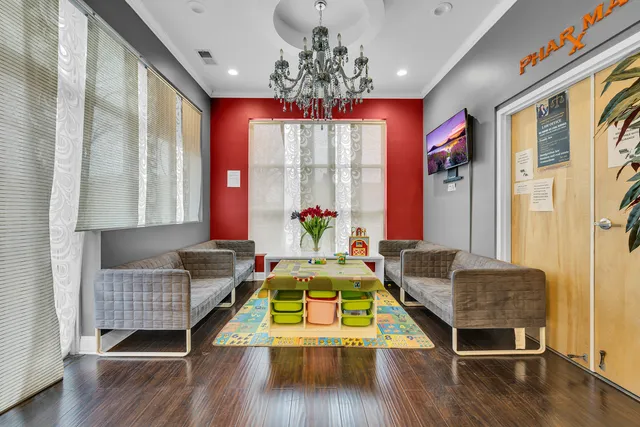 a living room with furniture kitchen view and a chandelier