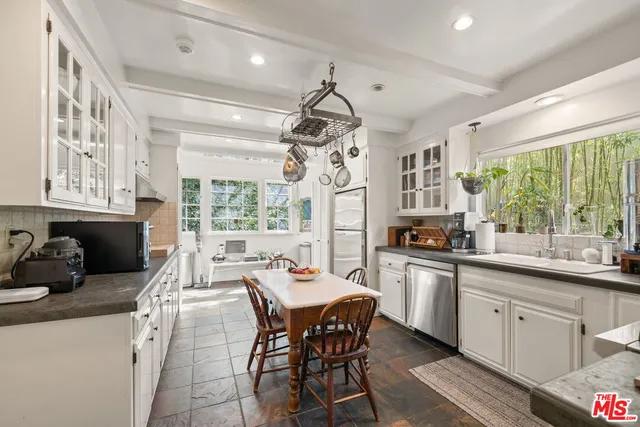 a kitchen with stainless steel appliances granite countertop sink stove top oven and cabinets