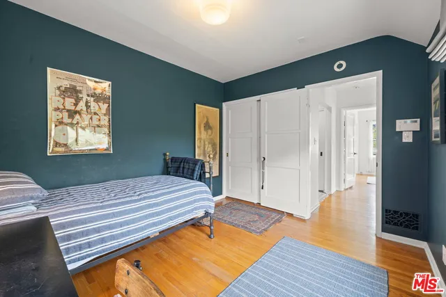 a bedroom with a bed and wooden floor