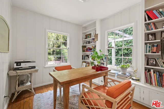 a view of a workspace with furniture and a book shelf