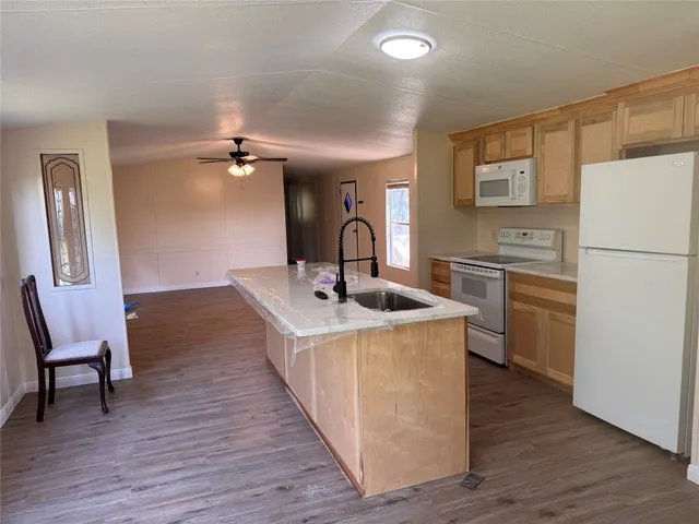a kitchen with kitchen island a stove a sink and a refrigerator
