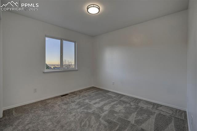 7790 Julynn Road Colorado Springs, CO 80919 - Photo 22 of 50 Main Level Bedroom #1 with new carpet and generous closet. Mountain and city views.
