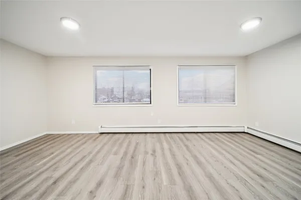 a view of an empty room with wooden floor