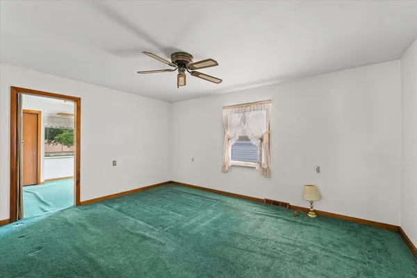 a storage room with stainless steel appliances wooden floor and window